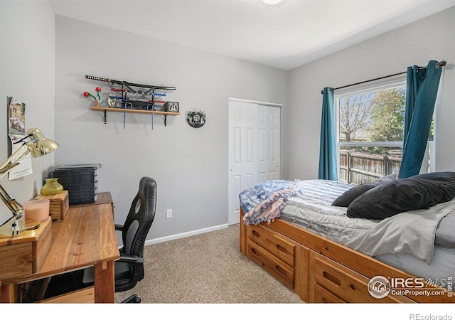 bedroom featuring baseboards, light carpet, and a closet