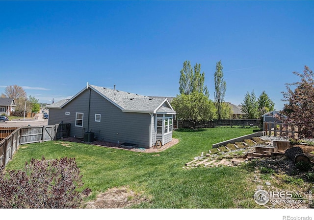 view of yard with central air condition unit and a fenced backyard