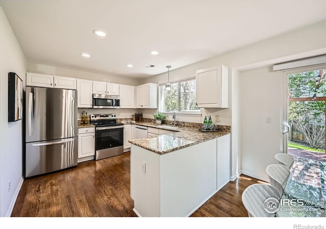 1507 Begonia Way, Superior, CO 80027 - kitchen with light stone counters, a sink, a peninsula, stainless steel appliances, and white cabinets