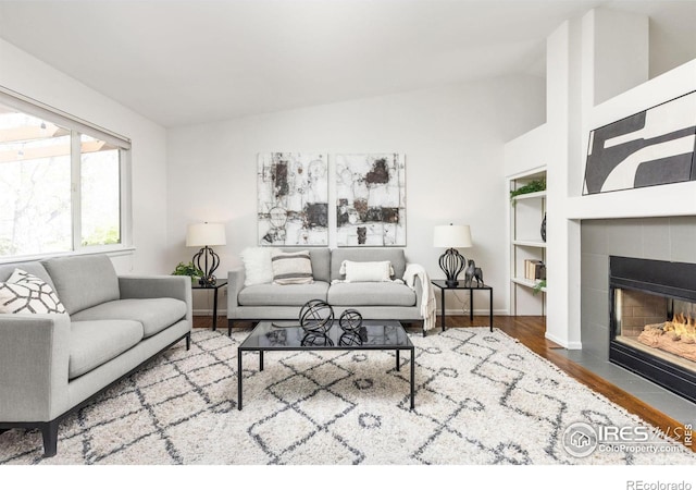 1507 Begonia Way, Superior, CO 80027 - living room with vaulted ceiling, a fireplace, baseboards, and wood finished floors