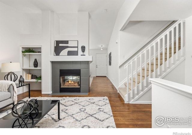 1507 Begonia Way, Superior, CO 80027 - living area featuring baseboards, stairway, a tile fireplace, and wood finished floors