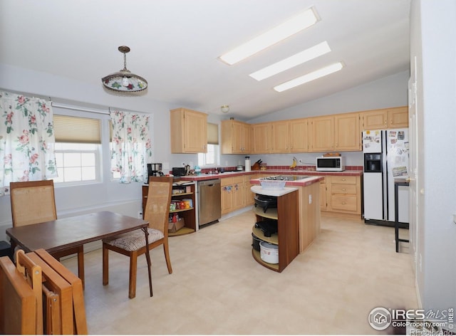 kitchen featuring a center island, vaulted ceiling, light brown cabinets, and white appliances