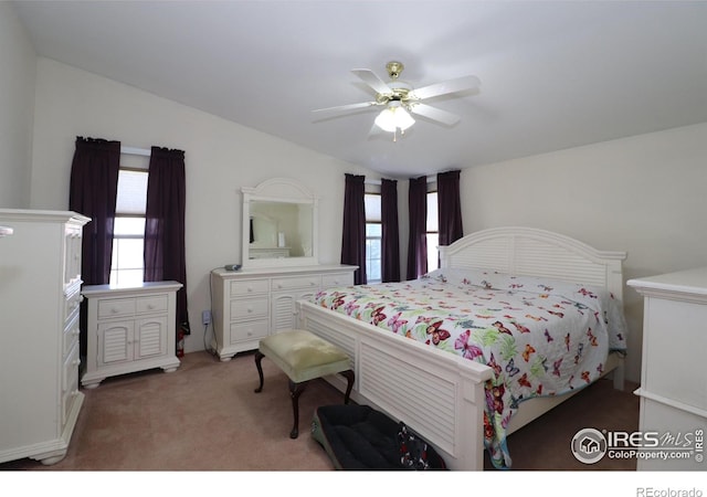 bedroom with a ceiling fan, lofted ceiling, and light carpet