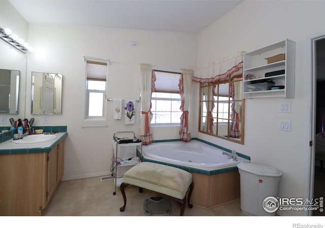 full bathroom with a jetted tub, baseboards, and vanity