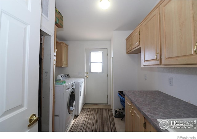 clothes washing area with cabinet space and washing machine and dryer