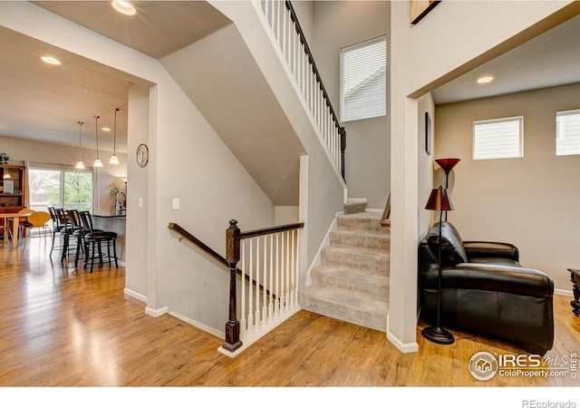 staircase featuring baseboards, recessed lighting, and wood finished floors