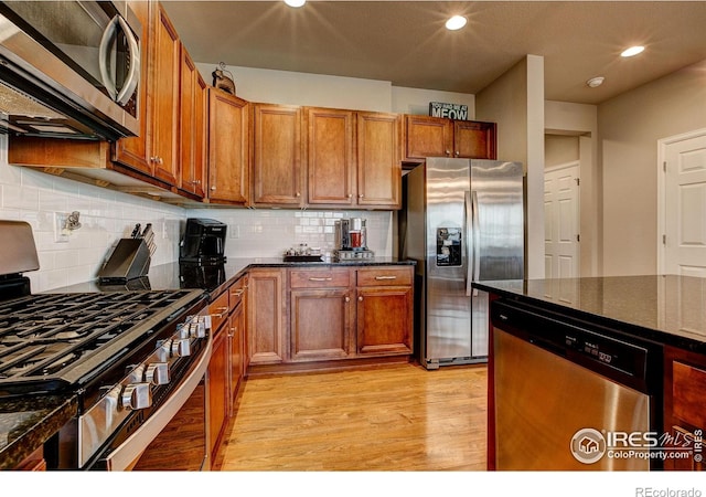 kitchen with stainless steel appliances, recessed lighting, brown cabinetry, and light wood finished floors