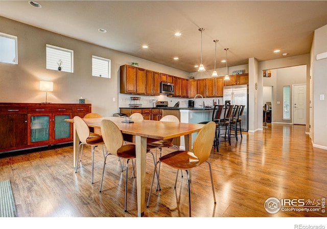 dining area featuring light wood-style floors, baseboards, and recessed lighting