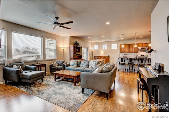 living area with recessed lighting, a ceiling fan, light wood finished floors, and a wealth of natural light