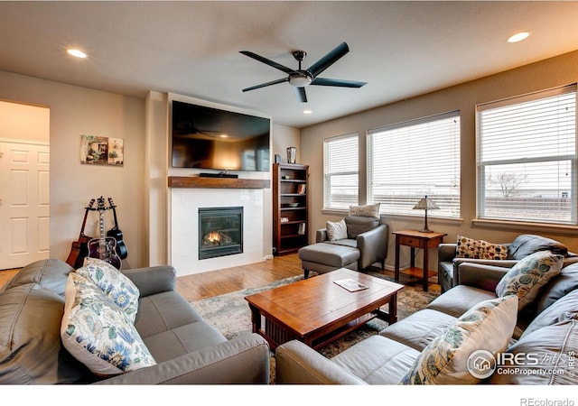 living room featuring a ceiling fan, recessed lighting, wood finished floors, and a tile fireplace