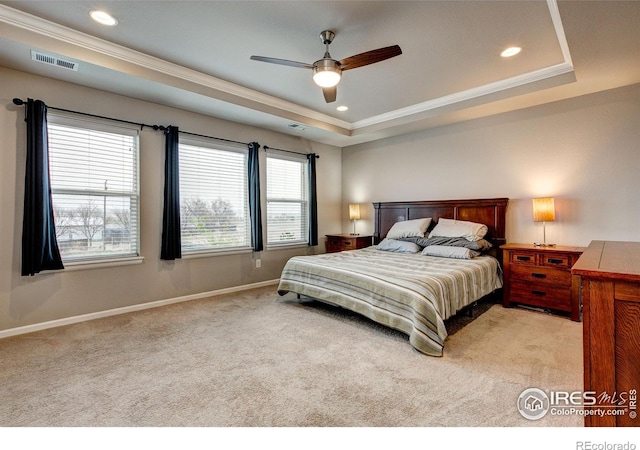 carpeted bedroom with visible vents, ornamental molding, baseboards, and a raised ceiling