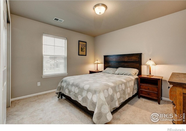 bedroom with visible vents, baseboards, and light carpet