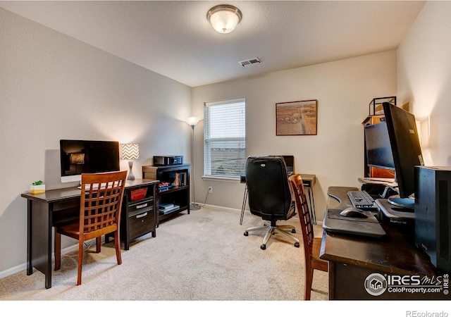 office space featuring carpet floors, baseboards, and visible vents