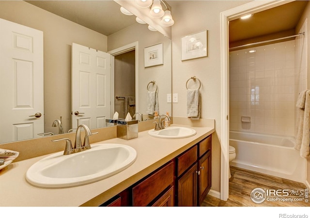 full bath with double vanity, a sink, shower / tub combo, and wood finished floors