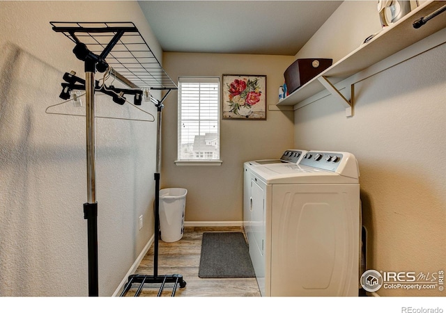 laundry area with baseboards, laundry area, light wood-style flooring, and independent washer and dryer