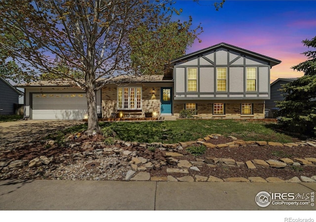 1309 Alexandria St, Lafayette, CO 80026 - view of front of property with driveway, an attached garage, brick siding, and stucco siding