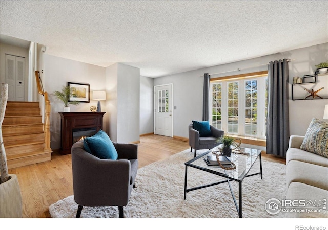 1309 Alexandria St, Lafayette, CO 80026 - living area featuring light wood-type flooring, a textured ceiling, stairway, and baseboards