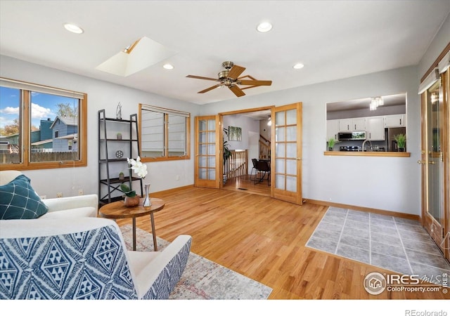 1309 Alexandria St, Lafayette, CO 80026 - living room featuring french doors, wood finished floors, a skylight, baseboards, and recessed lighting