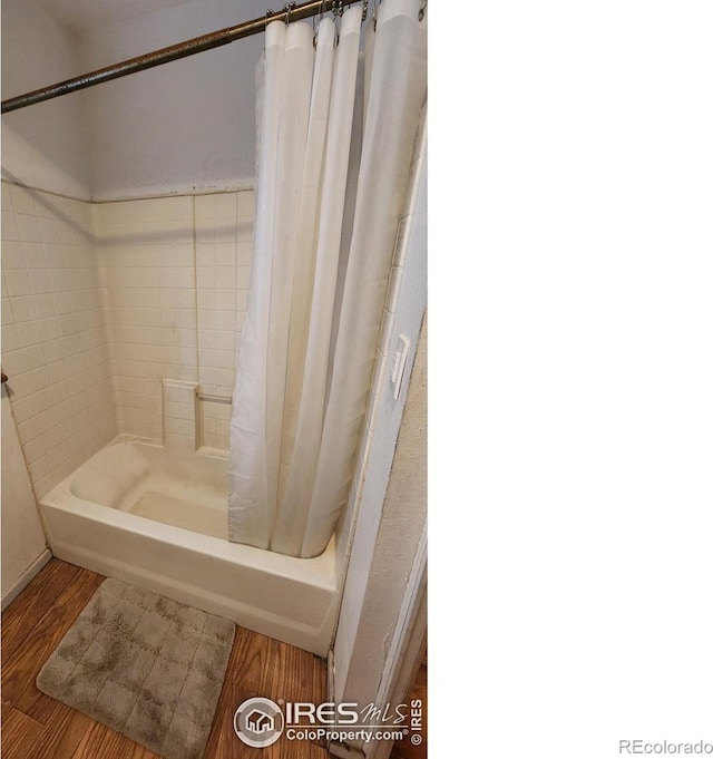 17233 County Road 16, Atwood, CO 80722 - full bath featuring shower / bathtub combination with curtain and wood finished floors