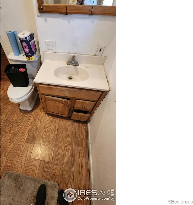 17233 County Road 16, Atwood, CO 80722 - bathroom with toilet, wood finished floors, and vanity
