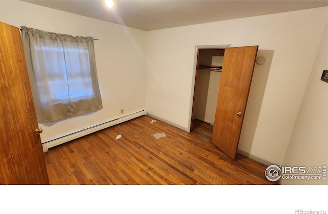 17233 County Road 16, Atwood, CO 80722 - unfurnished bedroom featuring wood finished floors and baseboard heating