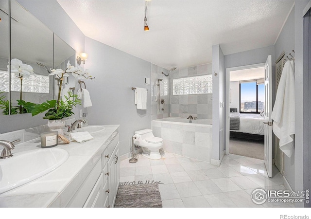 bathroom with double vanity, toilet, baseboards, and a sink