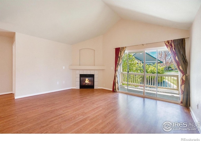 5225 White Willow Dr Unit 210, Fort Collins, CO 80528 - unfurnished living room featuring a tiled fireplace, baseboards, wood finished floors, and vaulted ceiling