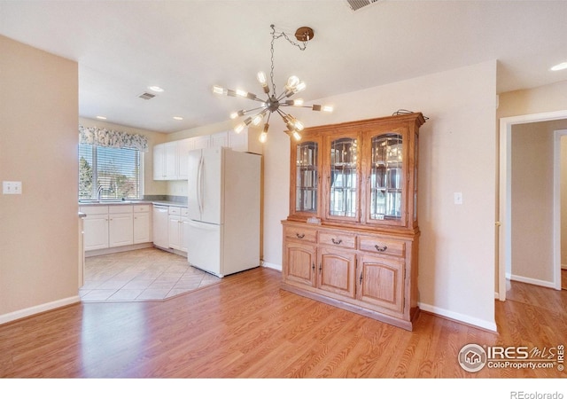 5225 White Willow Dr Unit 210, Fort Collins, CO 80528 - kitchen with an inviting chandelier, light wood finished floors, white cabinets, and white appliances