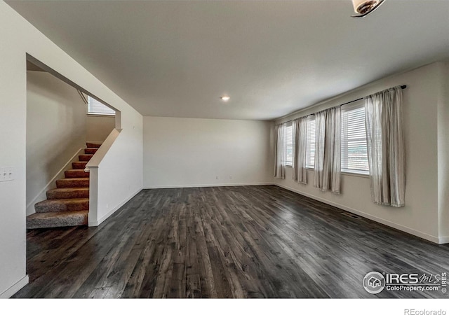 2325 Mountain Sky Dr, Fort Lupton, CO 80621 - unfurnished living room featuring dark wood-type flooring, stairs, baseboards, and recessed lighting