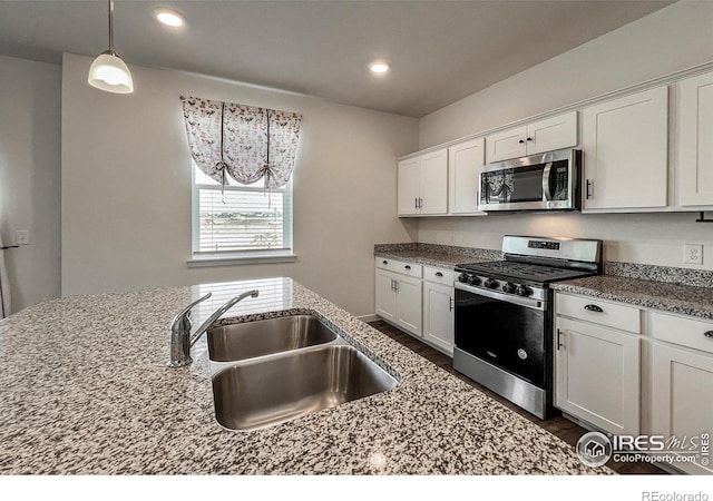 2325 Mountain Sky Dr, Fort Lupton, CO 80621 - kitchen with stainless steel appliances, a sink, white cabinetry, light stone counters, and recessed lighting