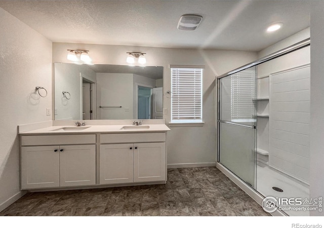 2325 Mountain Sky Dr, Fort Lupton, CO 80621 - bathroom with a stall shower, baseboards, and double vanity