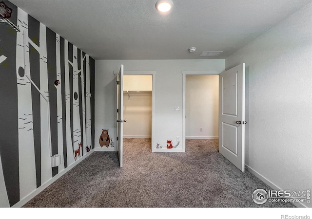 2325 Mountain Sky Dr, Fort Lupton, CO 80621 - unfurnished bedroom featuring carpet flooring, baseboards, and a walk in closet