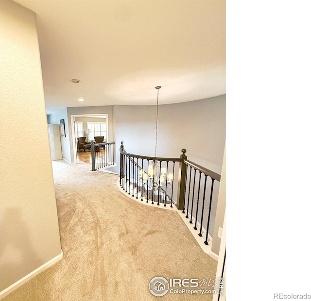 corridor featuring recessed lighting, baseboards, an upstairs landing, and carpet