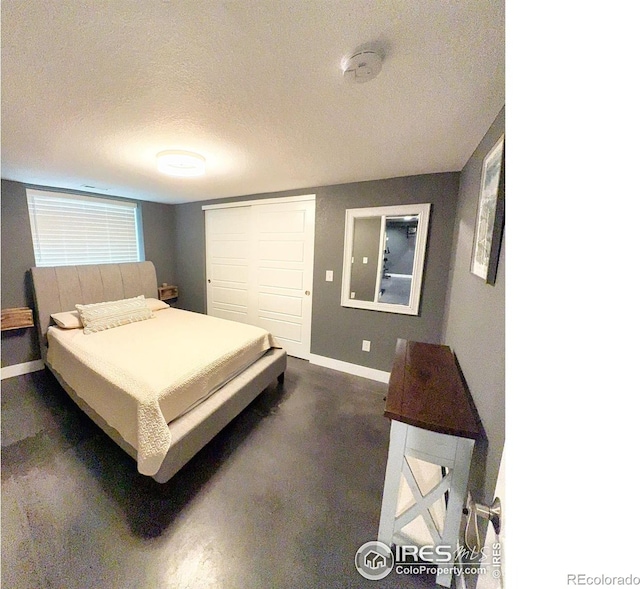 bedroom with baseboards, a closet, and a textured ceiling