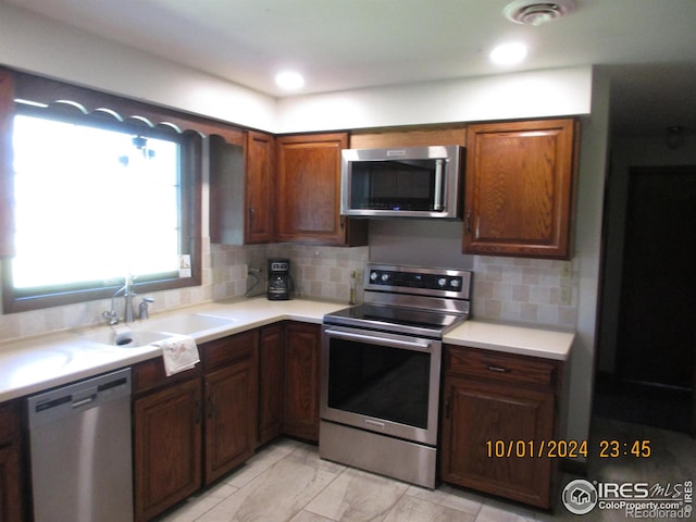 13969 County Road 33, Sterling, CO 80751 - kitchen featuring marble finish floor, light countertops, a sink, appliances with stainless steel finishes, and backsplash