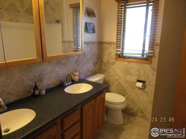 13969 County Road 33, Sterling, CO 80751 - full bath featuring double vanity, a sink, backsplash, and toilet