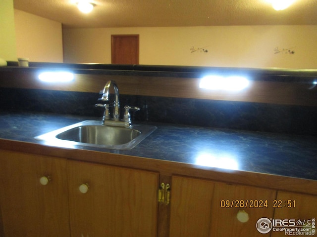 13969 County Road 33, Sterling, CO 80751 - kitchen featuring brown cabinets, dark countertops, decorative backsplash, and a sink