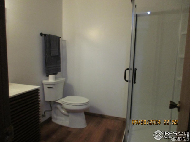 13969 County Road 33, Sterling, CO 80751 - bathroom featuring vanity, toilet, baseboards, a shower stall, and wood finished floors