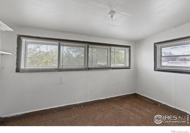 1626 11th Ave, Greeley, CO 80631 - empty room featuring dark colored carpet and baseboards
