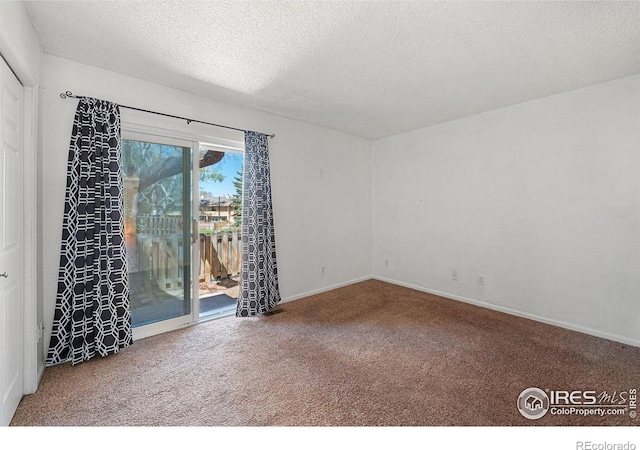 empty room featuring carpet floors, baseboards, and a textured ceiling