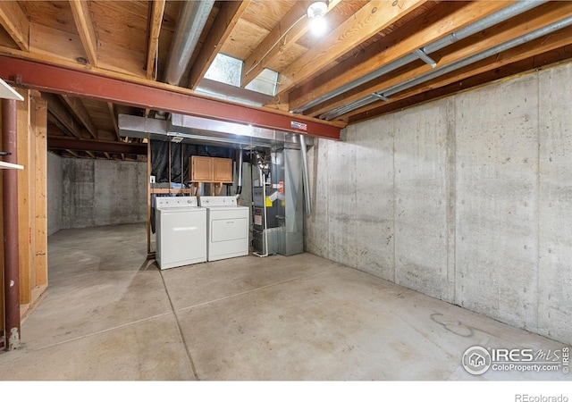 unfinished basement featuring heating unit and washer and dryer