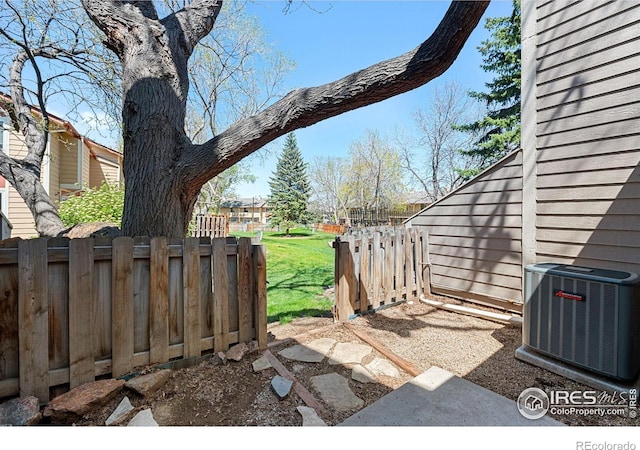 view of yard with fence and central AC