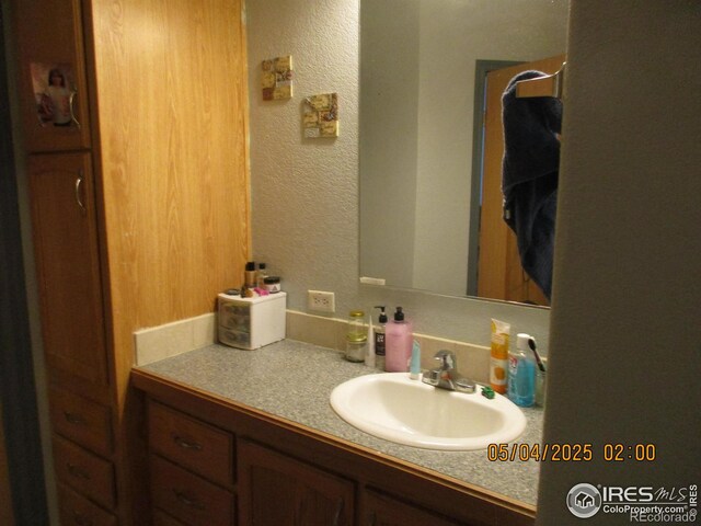 9021 County Road U.5, Weldona, CO 80653 - bathroom featuring vanity and a textured wall