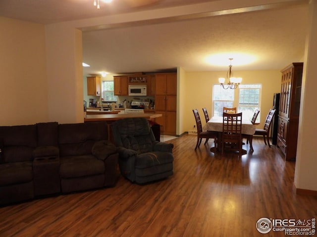 9021 County Road U.5, Weldona, CO 80653 - living area featuring dark wood-style floors, a chandelier, and baseboards