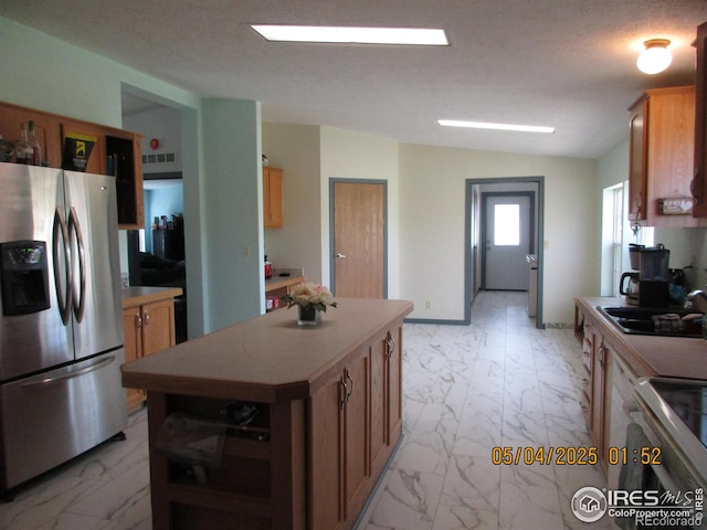 9021 County Road U.5, Weldona, CO 80653 - kitchen featuring stainless steel appliances, light marble finish flooring, light countertops, a sink, and vaulted ceiling