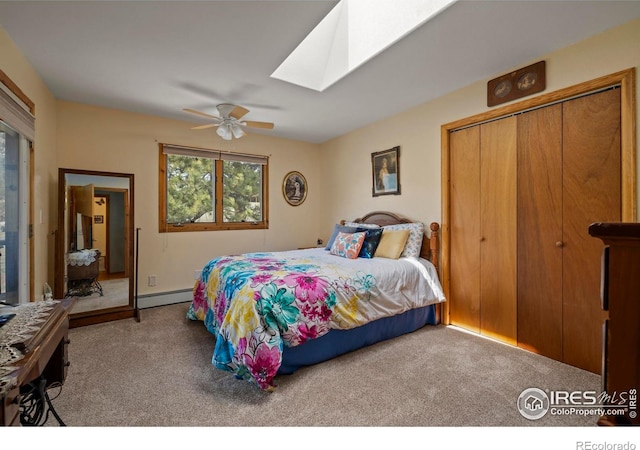bedroom with a ceiling fan, baseboard heating, a closet, carpet, and a skylight