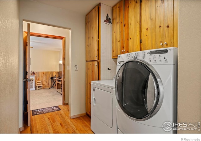 laundry area with washer and dryer, cabinet space, and light wood-style flooring