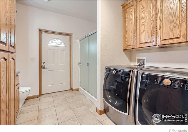 1720 Chaparro Cir, Berthoud, CO 80513 - washroom featuring cabinet space, washer and clothes dryer, baseboards, and light tile patterned floors