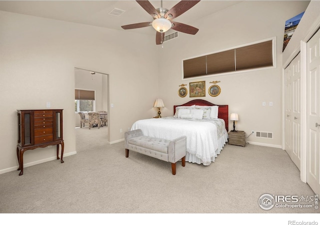 carpeted bedroom with visible vents, baseboards, and a ceiling fan