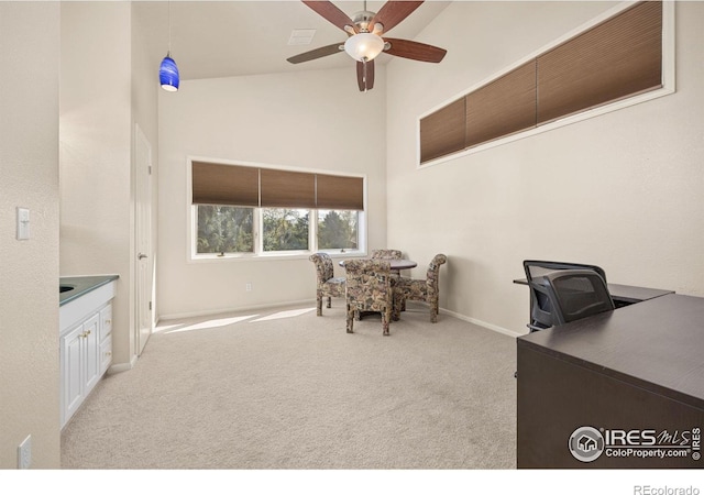 carpeted office with baseboards, a ceiling fan, and high vaulted ceiling